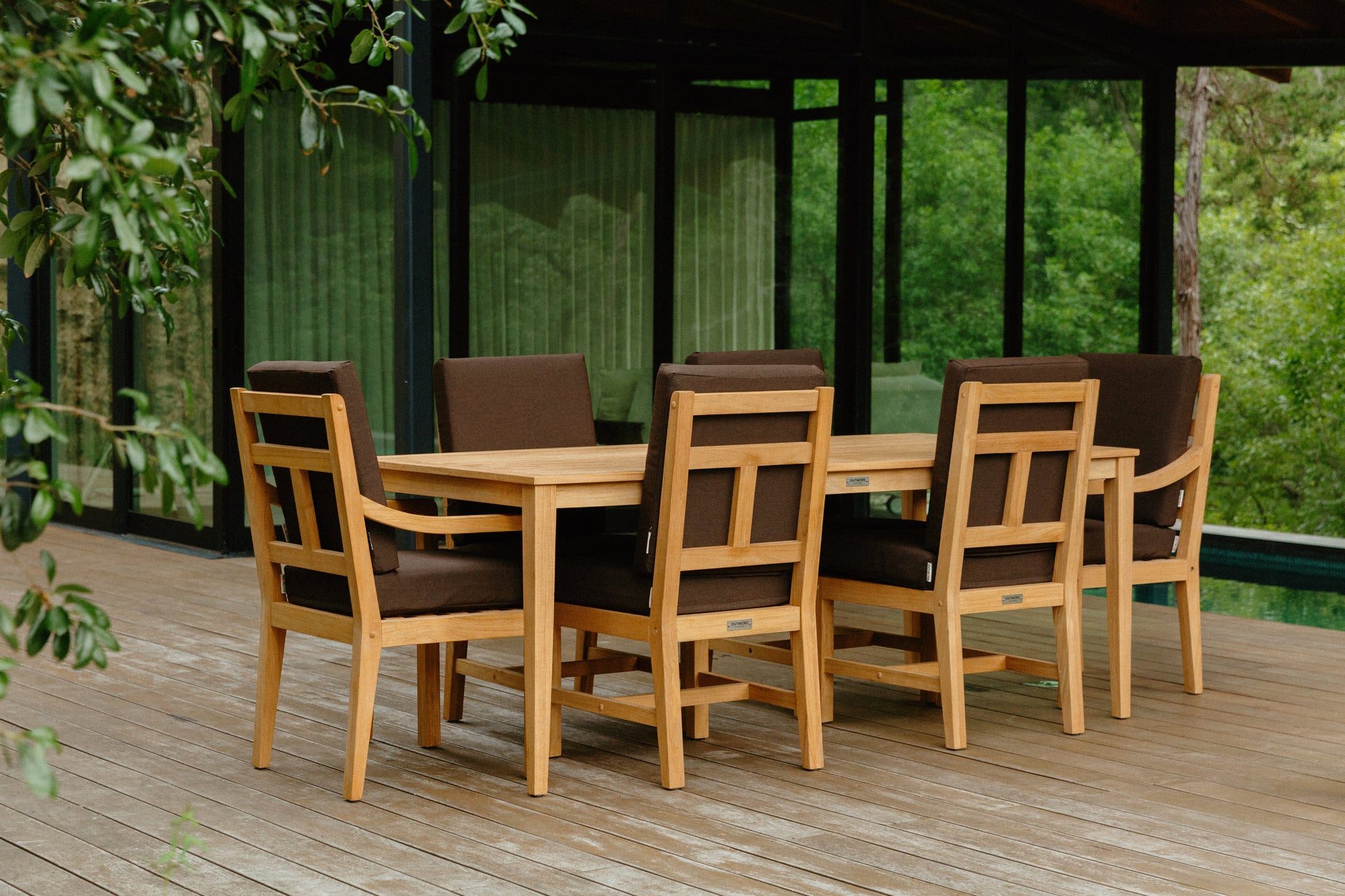Outmore teak outdoor dining set on a poolside deck